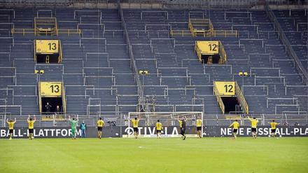 Bizarrer Jubel der Dortmunder Spieler vor der leeren Tribüne. Borussia Dortmund ist hierzulande der einzige an der Börse gehandelte Fußballverein. Im vergangenen Jahr (zum 30.6.) machte der Club coronabedingt einen Verlust von 45 Millionen Euro. Wegen des hohene Eigenkapitals von 355 Millionen steht der BVB dennoch relativ robust da.