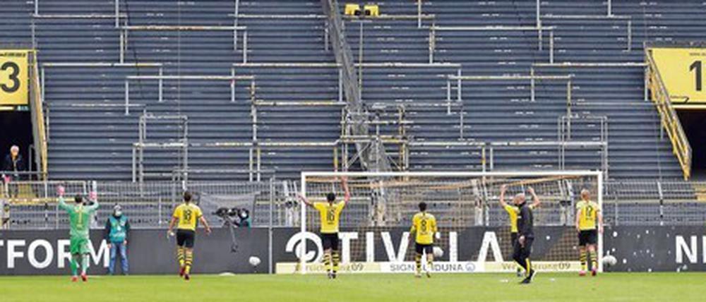 Bizarrer Jubel der Dortmunder Spieler vor der leeren Tribüne. Borussia Dortmund ist hierzulande der einzige an der Börse gehandelte Fußballverein. Im vergangenen Jahr (zum 30.6.) machte der Club coronabedingt einen Verlust von 45 Millionen Euro. Wegen des hohene Eigenkapitals von 355 Millionen steht der BVB dennoch relativ robust da.