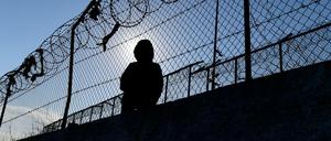 Ein Migrant sitzt neben einem Zaun des Flüchtlingslagers Moria. Berlin nimmt aus dem Hilfsprogramm des Bundes für Flüchtlinge in überfüllten Lagern auf den griechischen Inseln 142 Menschen auf.