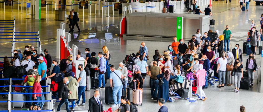 Reisende stehen in der Abflughalle im Terminal 1 am Flughafen in Frankfurt.