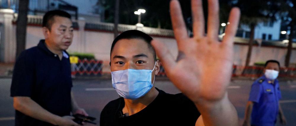 Ein Polizist in zivil geht auf einen Reuters-Fotografen zu, der Bilder vom US-Konsulat in Chengdu macht.