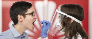 29.06.2020, Hessen, Frankfurt/Main: Zu Demonstrationszwecken entnimmt eine Mitarbeiterin der Firma Centogene einer Kollegin einen Rachenabstrich. In Zukunft sollen sich in Deutschlands erstem "Flughafen-Corona-Test"-Zentrum Menschen innerhalb weniger Stunden auf das Corona-Virus testen lassen können. Foto: Boris Roessler/dpa +++ dpa-Bildfunk +++ | Verwendung weltweit
