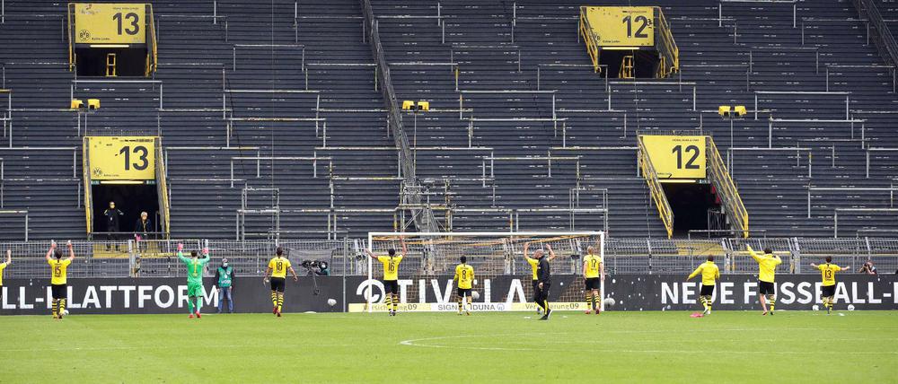 Bizarrer Jubel. Die Spieler von Borussia Dortmund nach dem Derbysieg gegen Schalke vor der leeren Südtribüne, auf der in normalen Zeiten 25 000 Fans stehen.