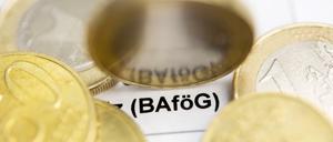 Auf einem Bafög-Antrag liegen Ein-Euro und 50-Cent-Münzen. Zu lesen ist der Schriftzug Bafög.