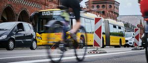 Einige Radfahrer fahren auf dem verbreiterten Radweg auf der Oberbaumbrücke. 