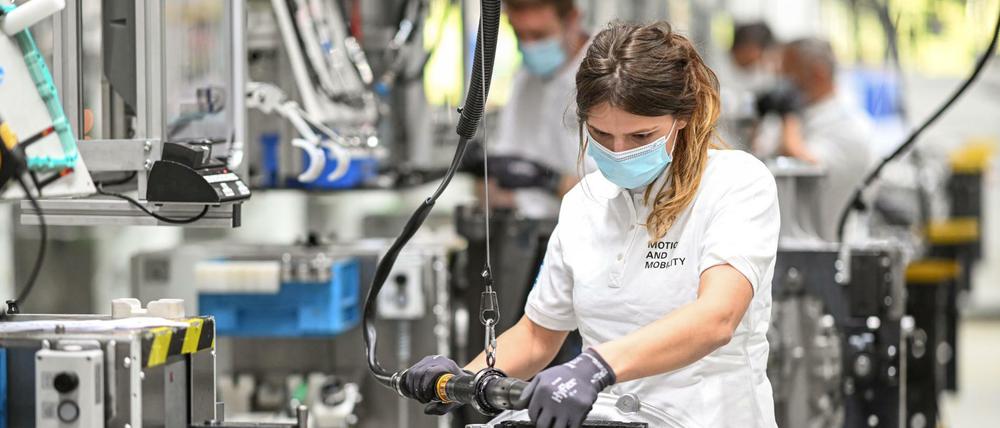Eine Monteurin arbeitet in einem Werk des Automobilzulieferers ZF Friedrichshafen an ein Getriebe für Lastwagen.