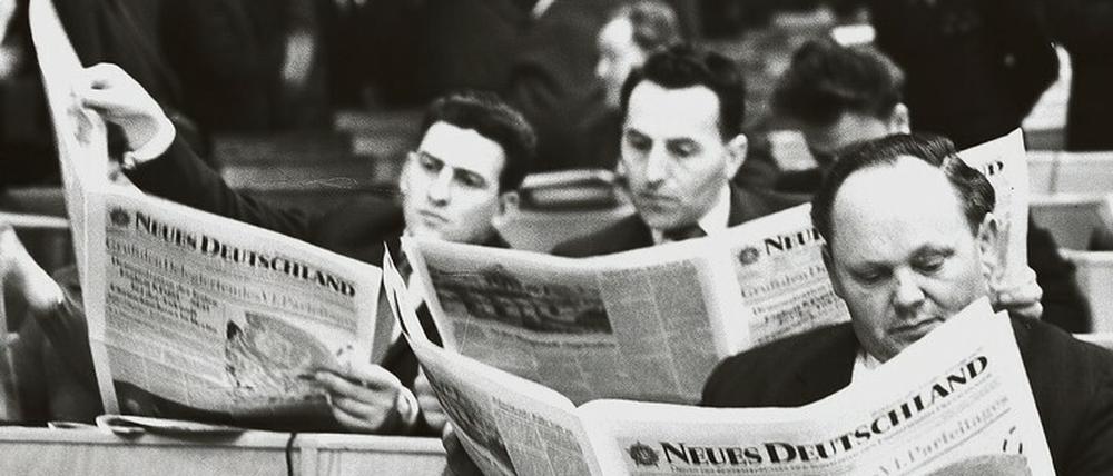 All the news that’s fit to print. Delegierte des VI. Parteitags der SED in der 1992 abgerissenen Werner-Seelenbinder-Halle in Prenzlauer Berg bei der Lektüre des „Neuen Deutschland“ (Januar 1963).