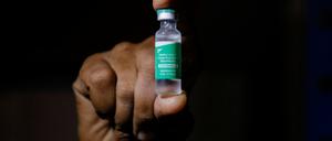 FILE PHOTO: A man displays a vial AstraZeneca's COVISHIELD vaccine as the country receives its first batch of coronavirus disease (COVID-19) vaccines under COVAX scheme, in Accra, Ghana February 24, 2021. REUTERS/Francis Kokoroko/File Photo