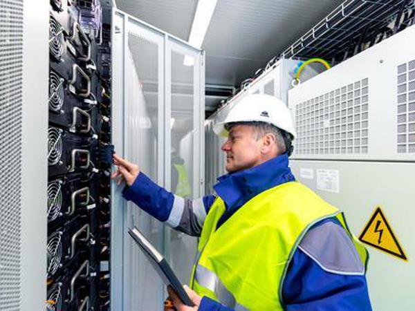 Ein Mann in Schutzkleidung arbeitet an einem Blocktransformator.