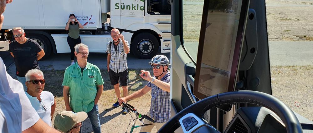 Unfallforscher Siegfried Brockmann (mit Helm) diskutiert mit Lkw-Fahrern.