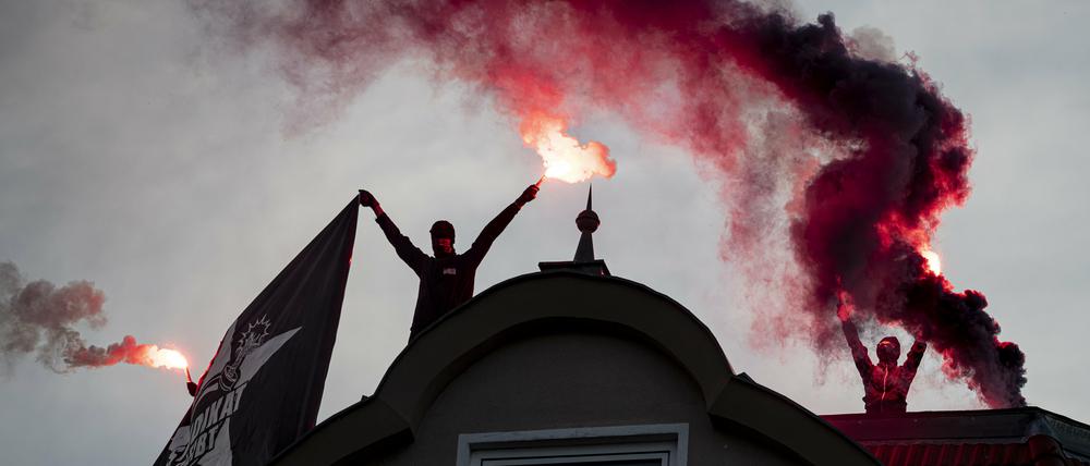 Demonstranten entzünden Bengalos auf einem Haus im Neuköllner Schillerkiez.