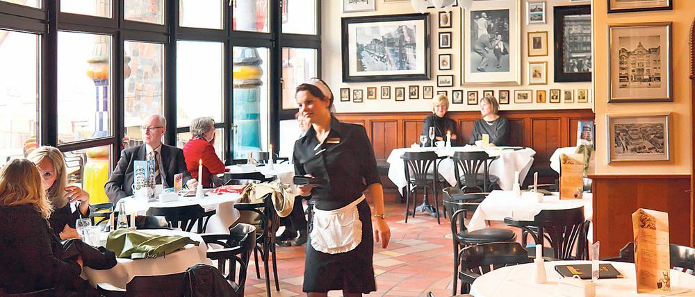 Eine junge Frau kellnert in einem Kaffeehaus.
