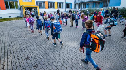 Kinder gehen am Montag in eine Schule in Schwerin.