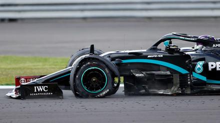 Lewis Hamilton steuert sein Fahrzeug mit einem platten Reifen über die Rennstrecke. 