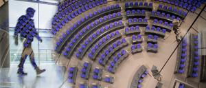Ein Abgeordneter spiegelt sich in der Scheibe der Reichstagskuppel über dem Plenarsaal des Bundestages.