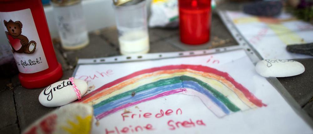 Bemalte Steine, Kinderzeichnungen und Plüschtiere liegen vor der Kita in Viersen.