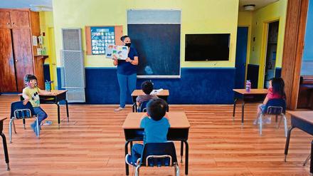 Unterricht in einer Vorschule in den USA, die Lehrerin und die Kinder tragen Masken.