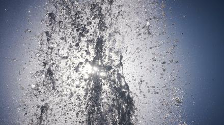 Sommer in Berlin: Das Wasser des Springbrunnens "Schwebender Ring" am Strausberger Platz glitzert in der Sonne.