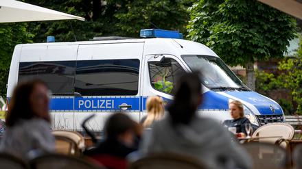 Ein Einsatzfahrzeug der Polizei fährt an einem Lokal am Alexanderplatz vorbei. Nachdem die Corona-Regeln häufig missachtet wurden, erwägt die Gesundheitssenatorin ein Alkoholverbot in Bars.