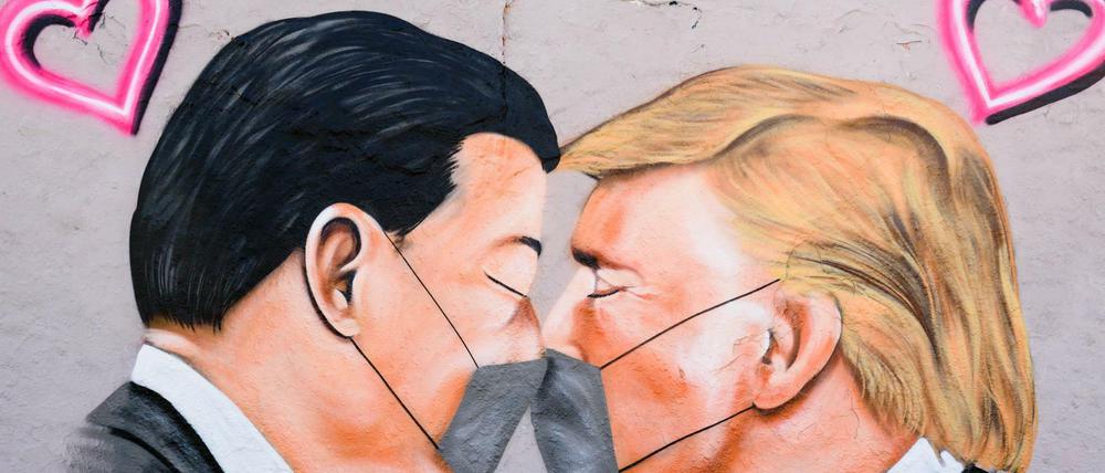 Auf einem Graffiti im Berliner Mauerpark kommen sich China Präsident Xi Jinping und US-Präsident Donald Trump näher - mit Maske versteht sich.