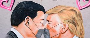 Auf einem Graffiti im Berliner Mauerpark kommen sich China Präsident Xi Jinping und US-Präsident Donald Trump näher - mit Maske versteht sich.