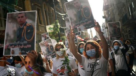 Die Teilnehmerinnen halten Fotos der Verstorbenen hoch.