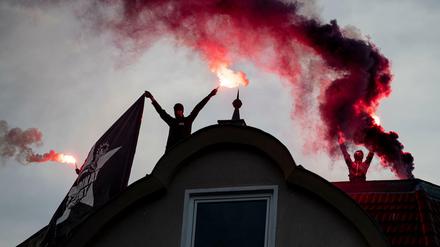 Demonstranten zünden während einer Demonstration gegen die Räumung der Szene-Kneipe Syndikat auf einem Dach Rauchpatronen.