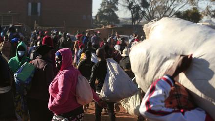 Menschen in Simbabwe warten an einem Busbahnhof. Präsident Mnangagwa kündigte strengere Maßnahmen an, um die steigende Zahl von Corona-Infektionen einzudämmen. 
