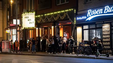 Menschen stehen unweit der Torstraße vor einem Lokal. 