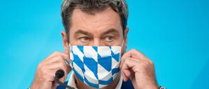 CSU-Chef Markus Söder zieht seine Maske nach der Videokonferenz wieder auf.