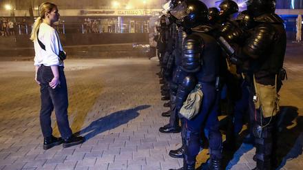 Eine Frau spricht zu Polizisten während Ausschreitungen infolge der Präsidentschaftswahl in Minsk.