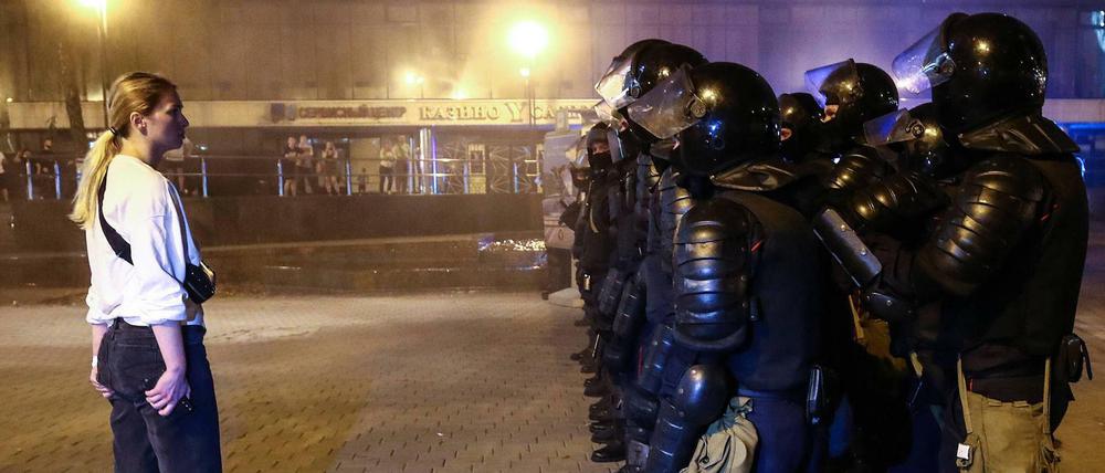 Eine Frau spricht zu Polizisten während Ausschreitungen infolge der Präsidentschaftswahl in Minsk.