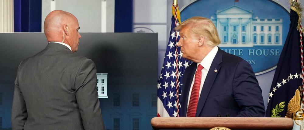 Abbruch: Ein Sicherheitsbeamter geleitet US-Präsident Trump aus der Pressekonferenz. 