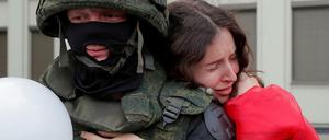 Eine Frau umarmt einen Soldaten vor dem Regierungsgebäude in Minsk. 