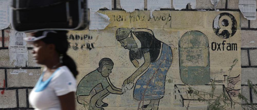 Hilfe für displaced people. Passantin vor einem Lager am Rande von Port-au-Prince in Haiti, das nach dem verheerenden Erdbeben 2010 errichtet wurde.