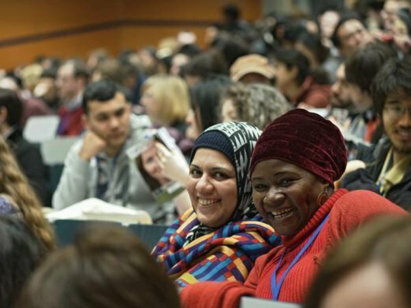 Internationale Studierende und Lehrende sitzen im Hörsaal einer deutschen Universität.