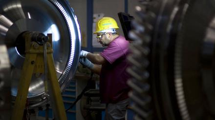 Ein Ingenieur arbeitet an einem Rotor einer Gasturbine bei der Siemens AG in der Turbinenhalle in Berlin. 