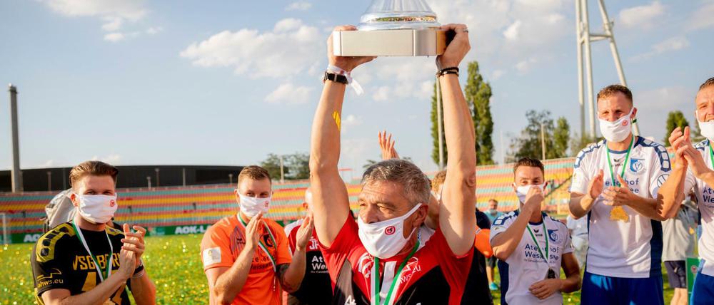 Hoch die Tassen: Altglienickes Trainer Kasten Heine reckt den Pokal empor.