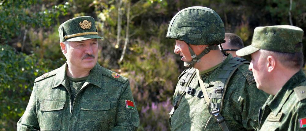Alexander Lukaschenko (l), Präsident von Belarus, spricht bei einer Militärübung mit hochrangigen Offizieren.