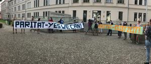 Vor dem Gerichtsgebäude gibt es Proteste. Der Frauenpolitische Rat verteilt Masken, auf denen Pari Pari steht.