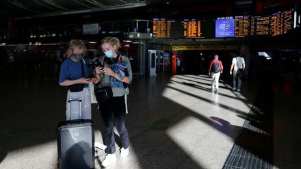 Reisende tragen Mundschutz im Hauptbahnhof Termini in Rom.