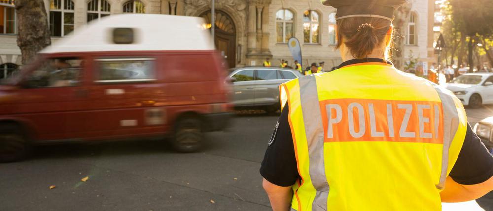 Eine Polizistin steht am frühen Morgen zu Schulbeginn vor einer Schule in Berlin.