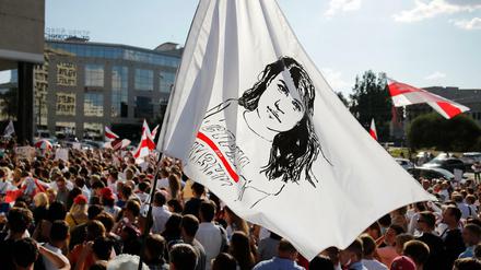 Ein Demonstrant schwenkt eine Flagge mit dem Gesicht der belarussischen Präsidentenkandidatin Tichanowskaja. Tichanowskaja ruft zum landesweiten Streik auf.
