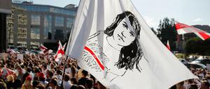 Ein Demonstrant schwenkt eine Flagge mit dem Gesicht der belarussischen Präsidentenkandidatin Tichanowskaja. Tichanowskaja ruft zum landesweiten Streik auf.