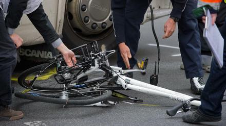 Symbolbild: Polizisten und Gutachter bergen in Berlin ein zertrümmertes Fahrrad unter einem Lkw nach einem Unfall. 