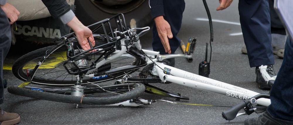 Symbolbild: Polizisten und Gutachter bergen in Berlin ein zertrümmertes Fahrrad unter einem Lkw nach einem Unfall. 