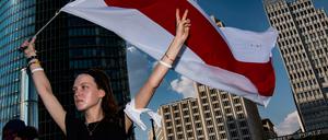  Viktoria steht mit der Fahne von Belarus auf dem Potsdamer Platz. Dort demonstrierten mehr als 100 Menschen gegen die Verletzung der Menschenrechte in Belarus - am Wochenende sollen es 1000 werden.