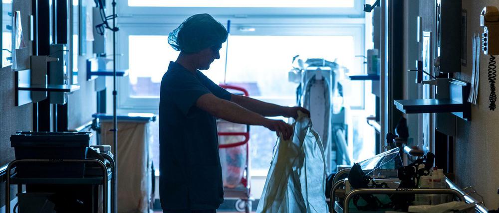 Eine Krankenschwester legt auf der Isolierstation für Coronavirus-Behandlungen einer Klinik Schutzkleidung an, bevor sie ein Patientenzimmer betritt.