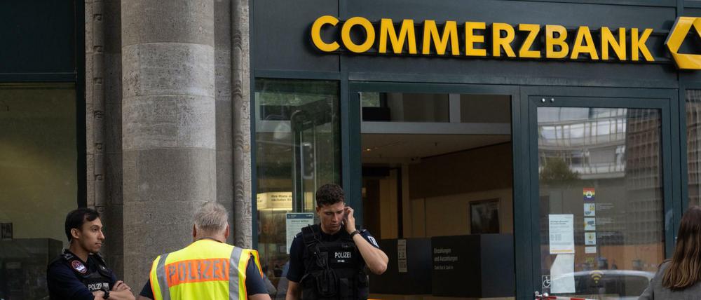 Polizisten stehen nach dem Überfall vor der Commerzbank-Filiale am Kurfürstendamm in Charlottenburg.