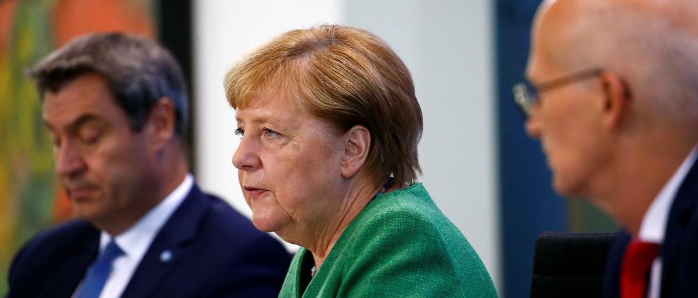 Bundeskanzlerin Angela Merkel (CDU) mit dem bayerischen Ministerpräsidenten Markus Söder (CSU, l) und Hamburgs Erstem Bürgermeister, Peter Tschentscher (SPD).